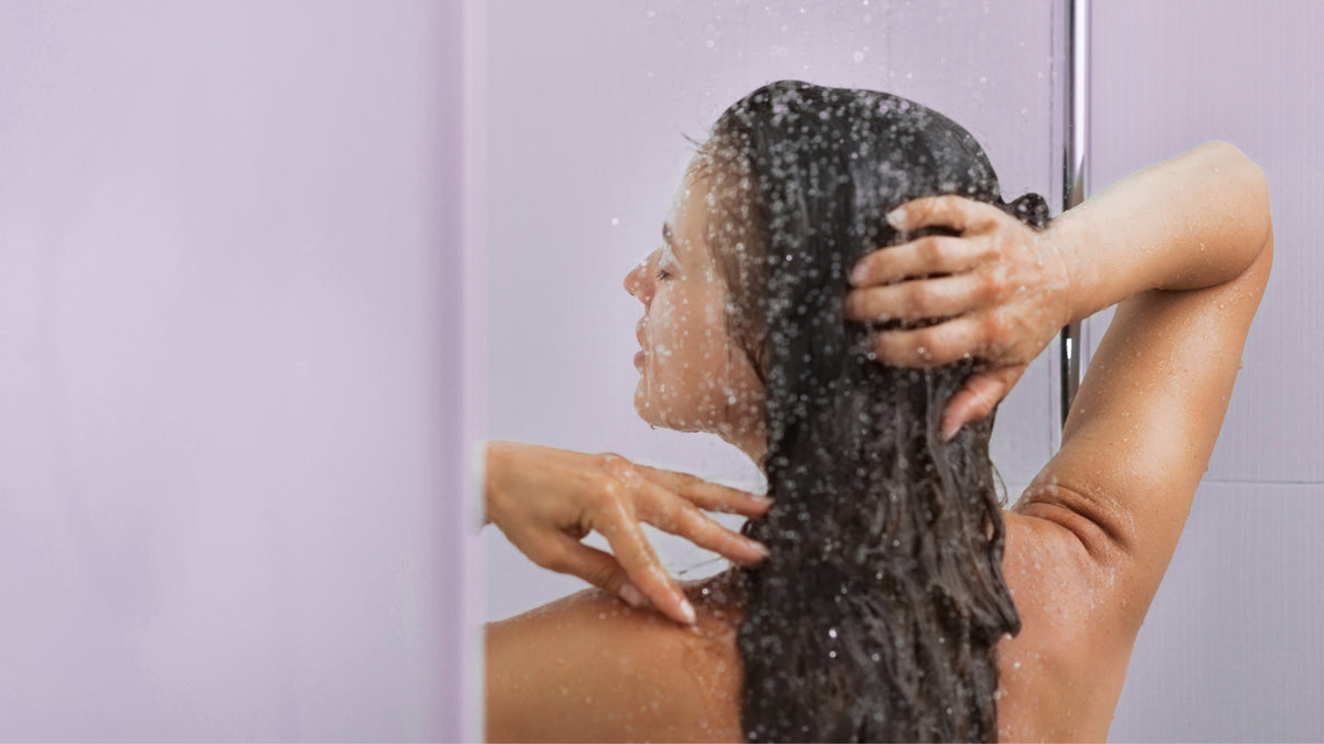 women with dark hair washing her hair. Relaxing and taking a moment to herself/